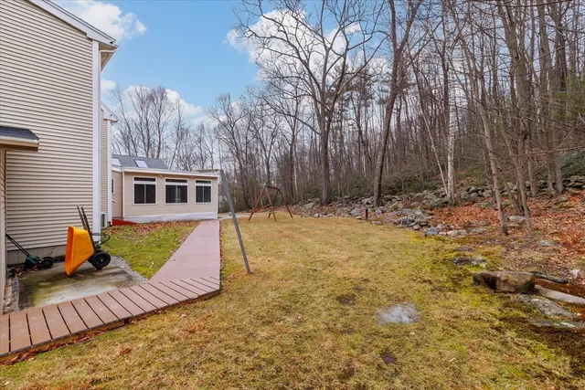 a view of a house with backyard and trees