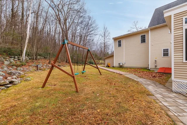 a view of a house with backyard and tree
