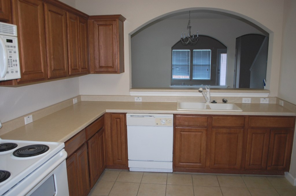 11300 Dimmit Street Manor, TX 78653 - Photo 6 of 23 Functional kitchen with ample cabinetry and pass-through window connects to a dining space.