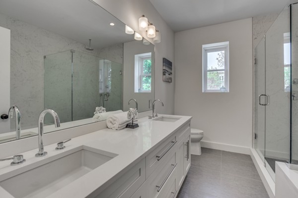 66 Perry Street, Unit 2 Brookline, MA 02446 - Photo 9 of 15 a bathroom with double vanity sink a toilet and a mirror