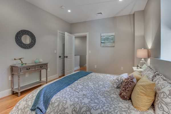 66 Perry Street, Unit 2 Brookline, MA 02446 - Photo 10 of 15 a bedroom with a bed and a chandelier