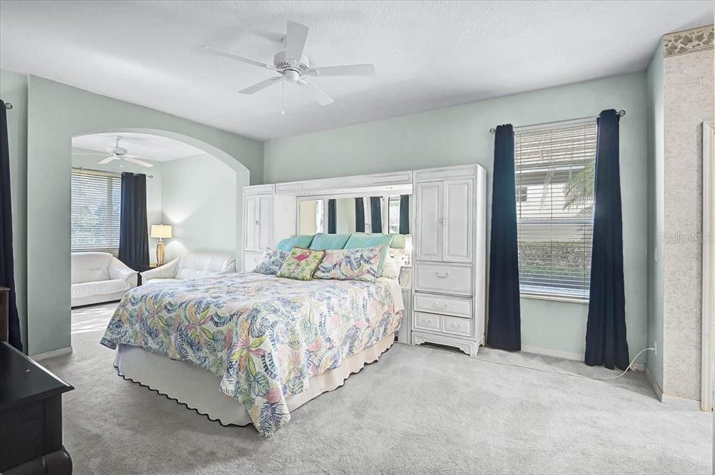 103 Bishopscourt Road Osprey, FL 34229 - Photo 15 of 55 a spacious bedroom with a bed and a chandelier
