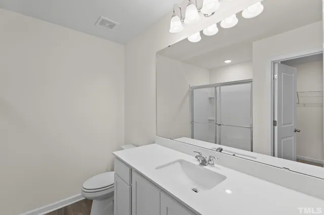 a bathroom with a sink vanity mirror and toilet