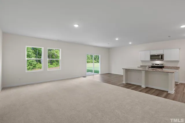 a view of kitchen with kitchen island stainless steel appliances a window and a counter top space