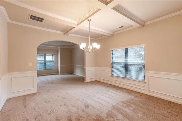 an empty room with windows and fireplace