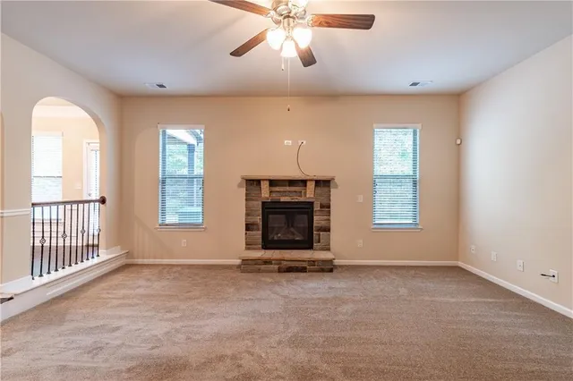 a view of an empty room with a fireplace and a window