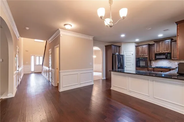 a view of a room with wooden floor chandelier and windows
