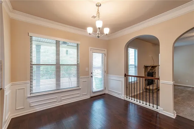 a kitchen with kitchen island granite countertop stainless steel appliances a sink a stove a refrigerator cabinets and wooden floor