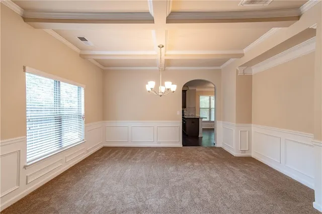 a view of a livingroom with a chandelier fan and windows