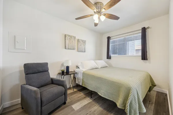 a bedroom with a bed couches and window