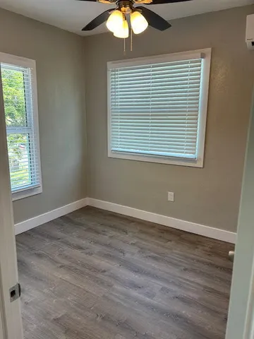an empty room with wooden floor and a window