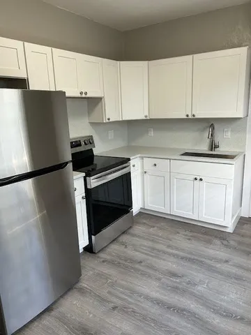 a kitchen with granite countertop white cabinets and white appliances