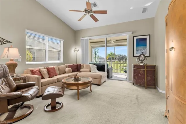 a living room with furniture and a floor to ceiling window
