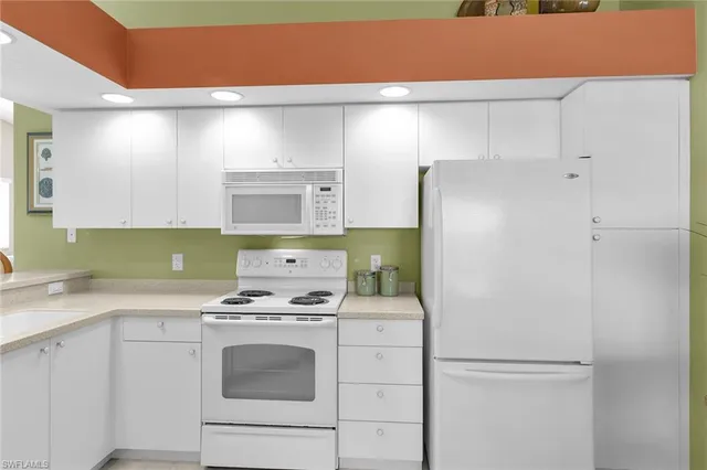 a kitchen with a refrigerator and a stove top oven