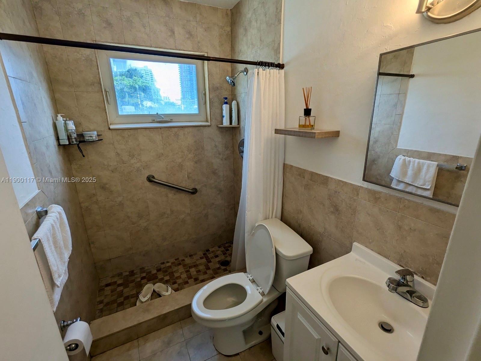 158 Ocean Drive, Unit 406 Miami Beach, FL 33139 - Photo 7 of 9 a bathroom with a sink toilet and shower