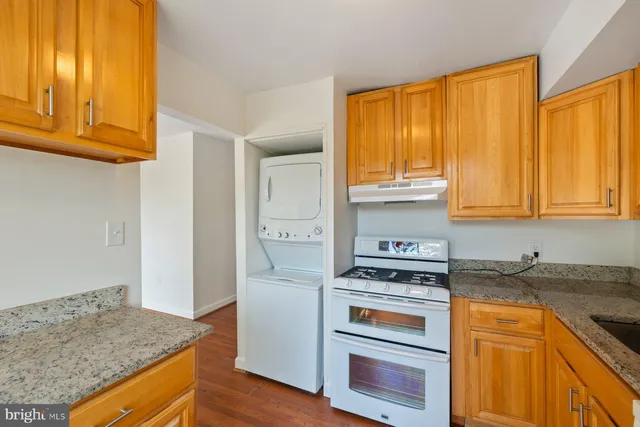 a kitchen with granite countertop wooden cabinets and a stove top oven