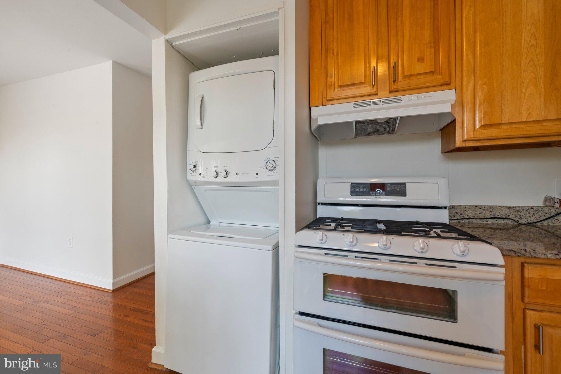 3946 Bel Pre Road, Unit 39466 Silver Spring, MD 20906 - Photo 12 of 27 a kitchen with granite countertop cabinets stainless steel appliances and wooden floor