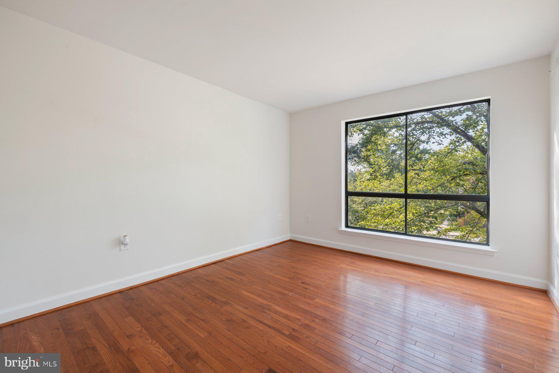 3946 Bel Pre Road, Unit 39466 Silver Spring, MD 20906 - Photo 16 of 27 an empty room with wooden floor and windows