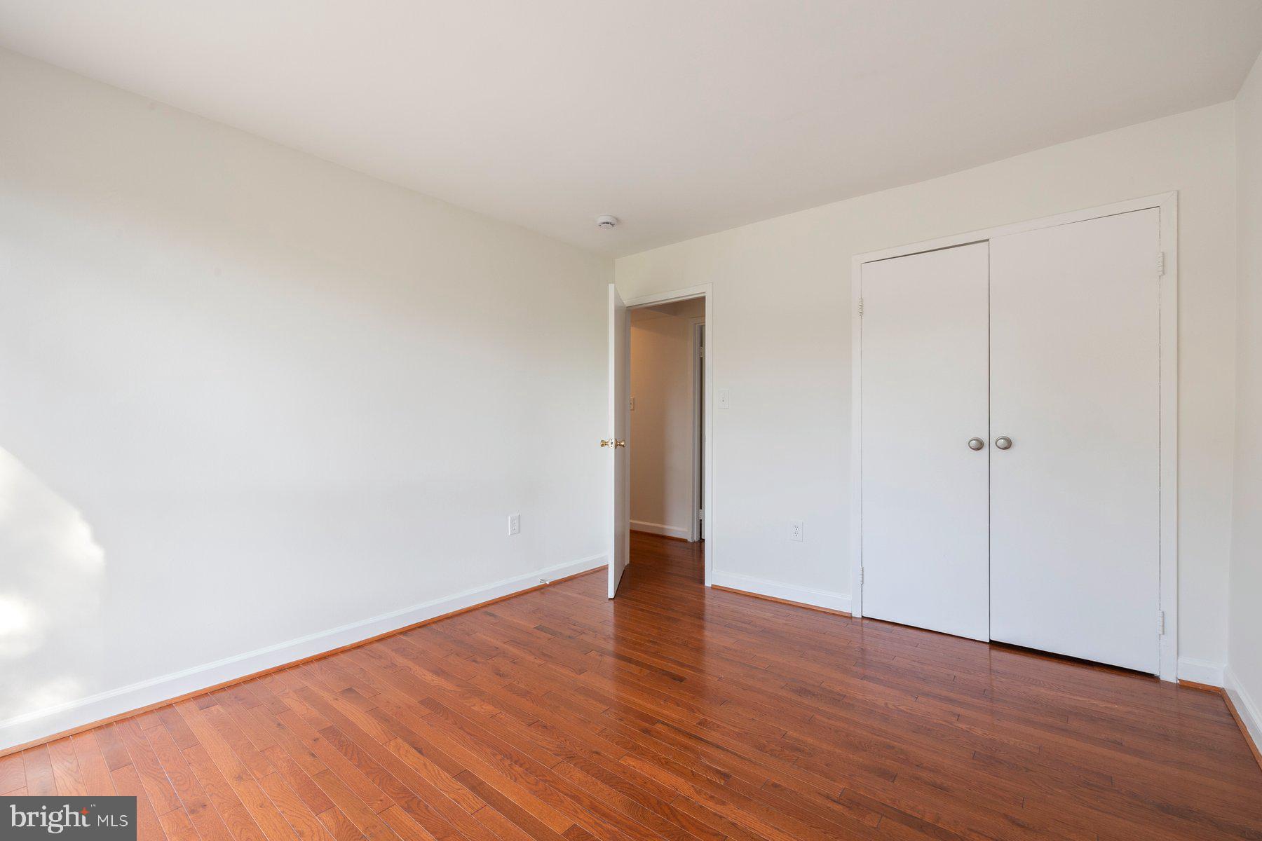 3946 Bel Pre Road, Unit 39466 Silver Spring, MD 20906 - Photo 17 of 27 a view of an empty room with wooden floor