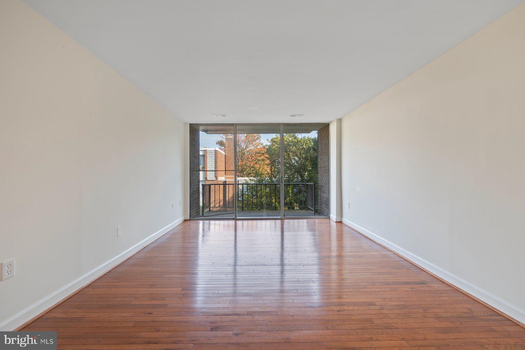 3946 Bel Pre Road, Unit 39466 Silver Spring, MD 20906 - Photo 25 of 27 a view of an empty room with wooden floor and a window