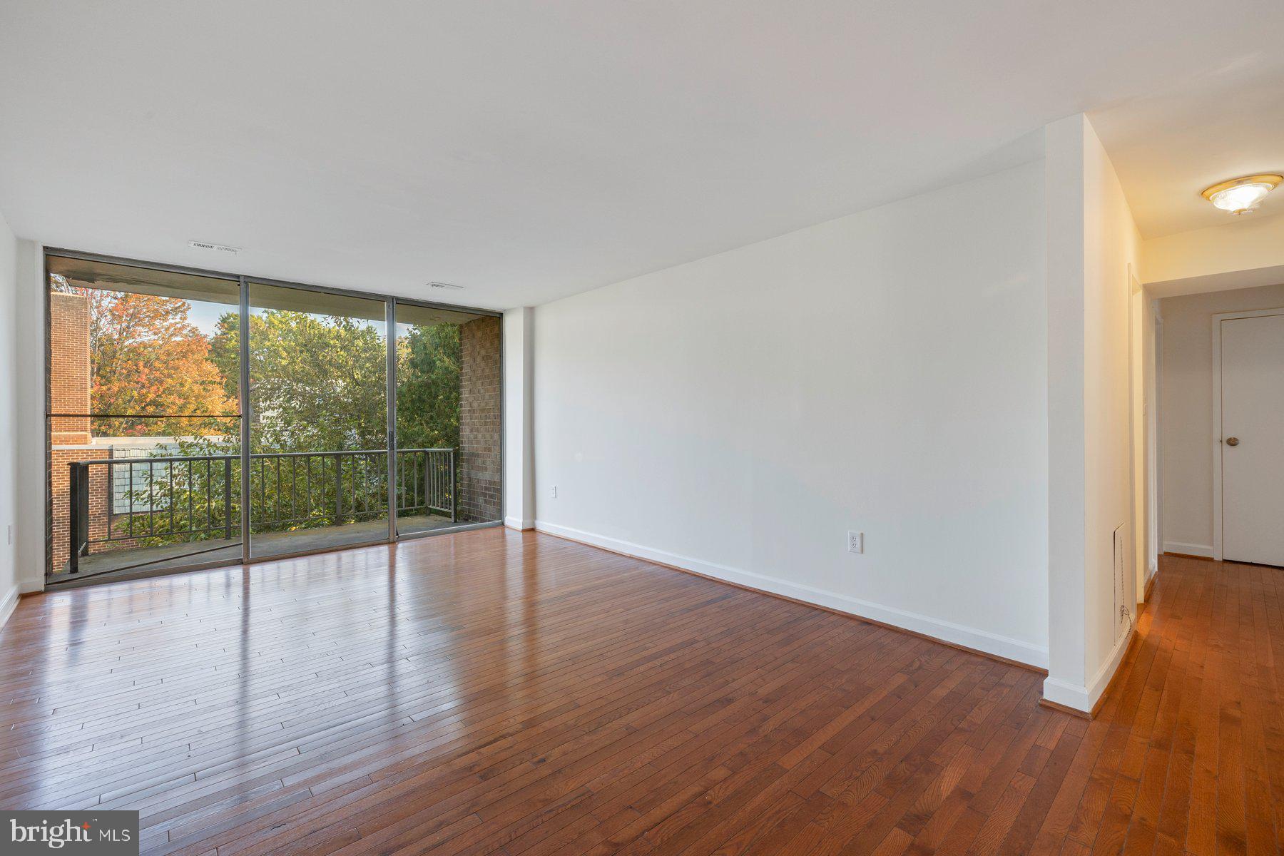 3946 Bel Pre Road, Unit 39466 Silver Spring, MD 20906 - Photo 3 of 27 wooden floor in an empty room with a window