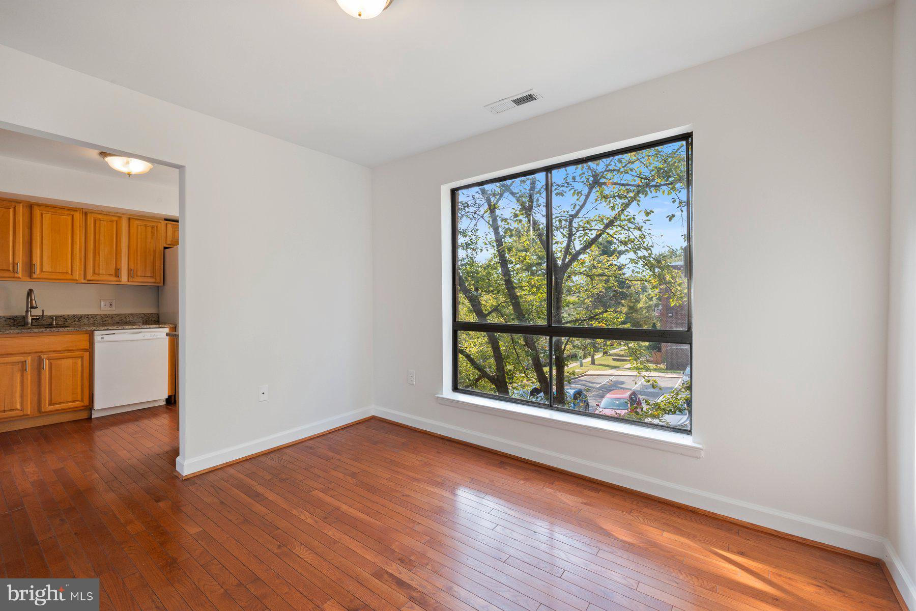 3946 Bel Pre Road, Unit 39466 Silver Spring, MD 20906 - Photo 7 of 27 wooden floor in an empty room with a window