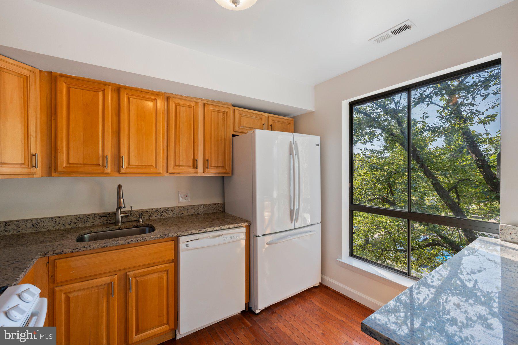 3946 Bel Pre Road, Unit 39466 Silver Spring, MD 20906 - Photo 9 of 27 a kitchen with appliances cabinets a sink and a large window