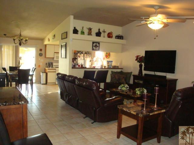 68205 Encinitas Road Cathedral City, CA 92234 - Photo 3 of 8 a living room with furniture a flat screen tv and kitchen view