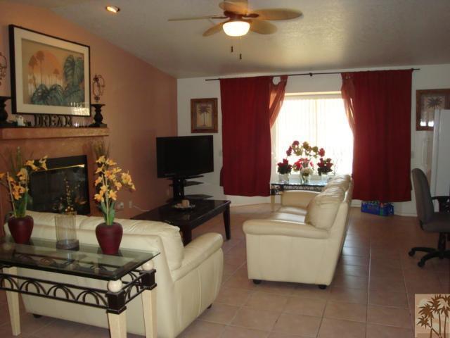 68205 Encinitas Road Cathedral City, CA 92234 - Photo 4 of 8 a living room with furniture a chandelier and a flat screen tv