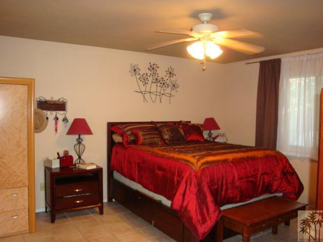 68205 Encinitas Road Cathedral City, CA 92234 - Photo 5 of 8 a bedroom with a bed and a chandelier