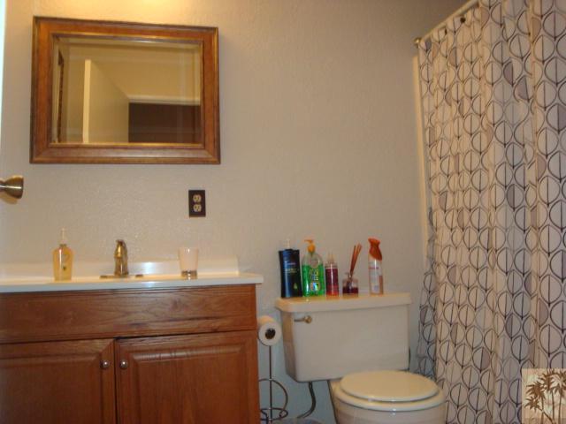 68205 Encinitas Road Cathedral City, CA 92234 - Photo 6 of 8 a bathroom with a granite countertop toilet sink and mirror