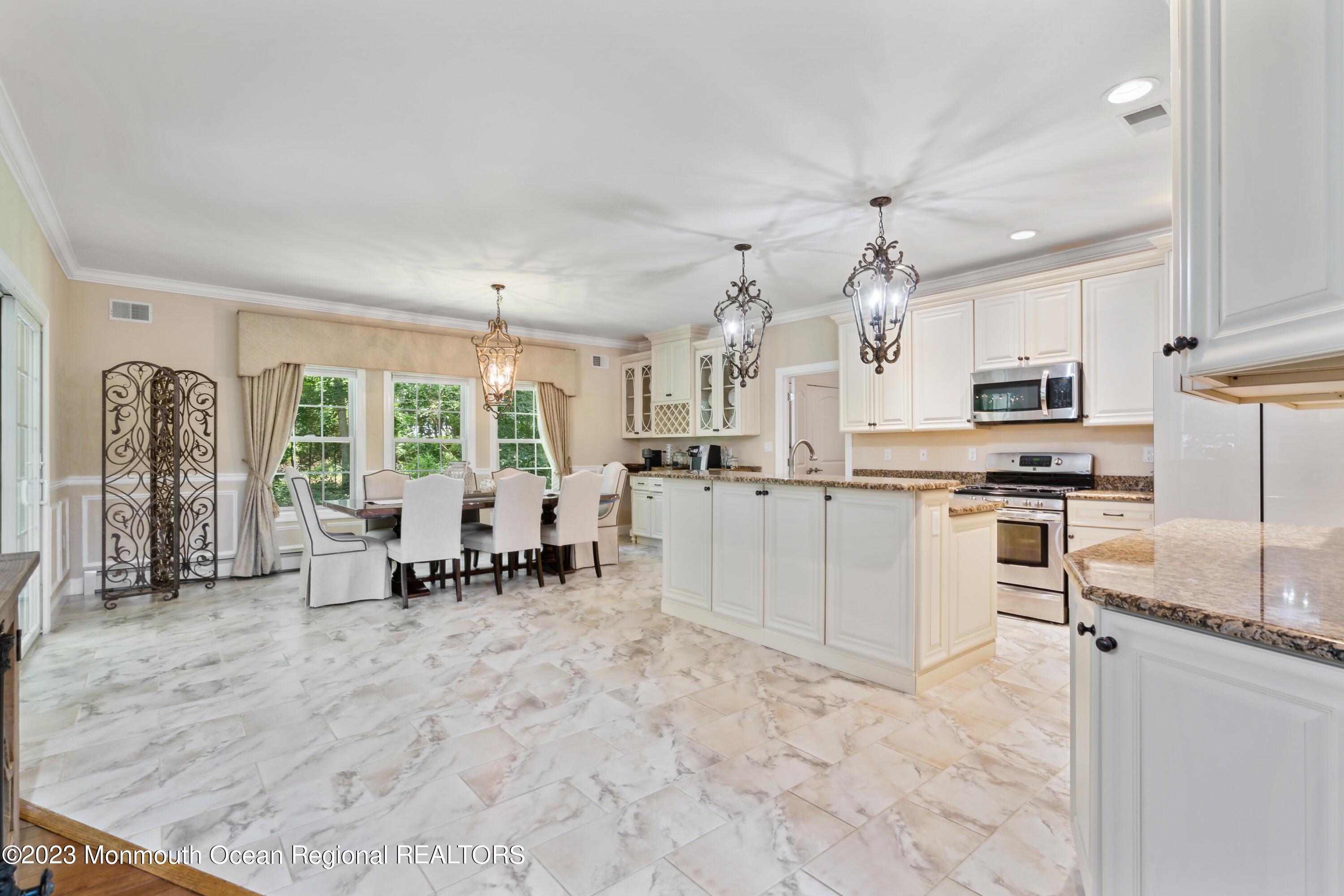 70 Bates Road Jackson, NJ 08527 - Photo 32 of 33 a kitchen with white cabinets and dining table