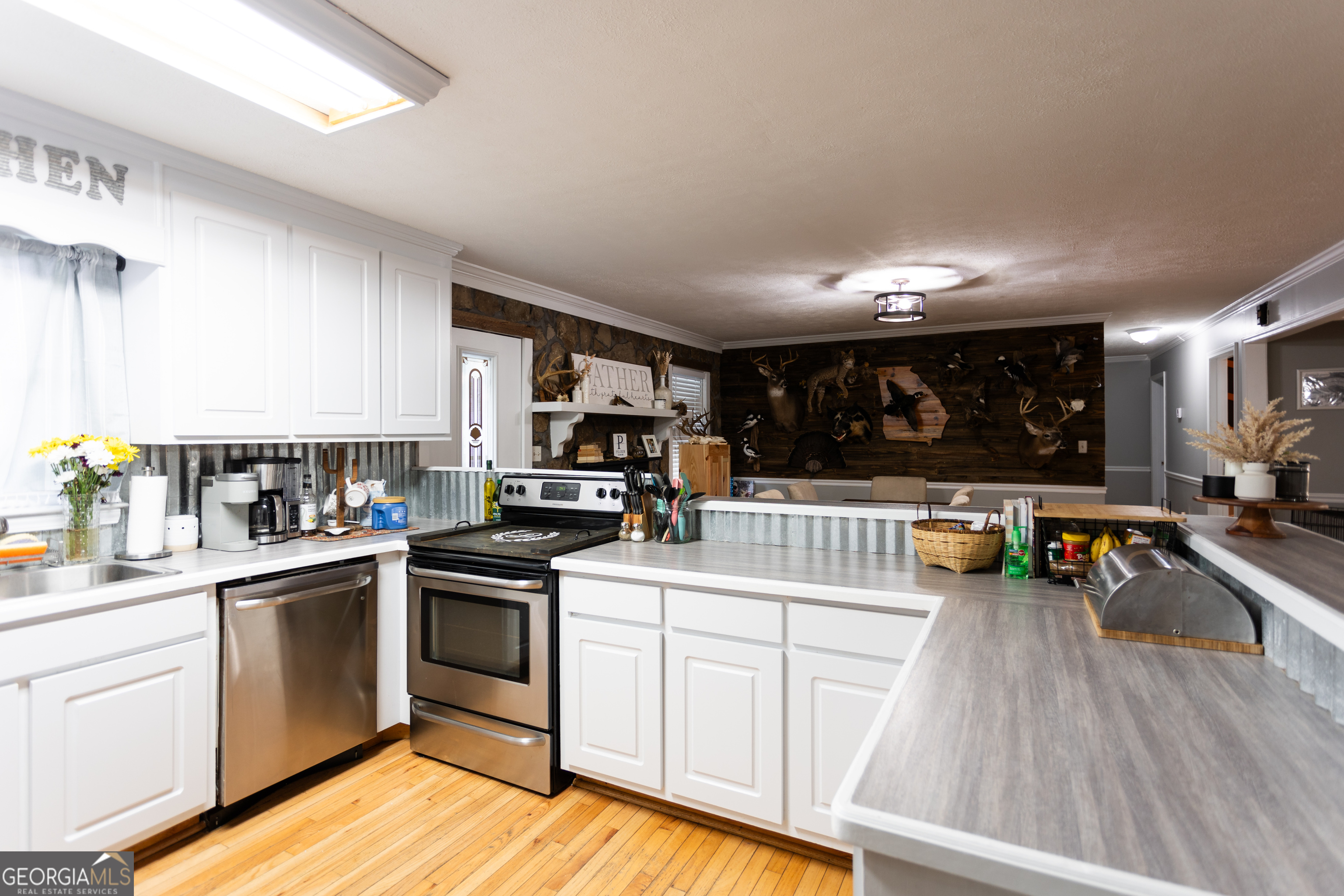 1585 Flat Rock Road Covington, GA 30014 - Photo 12 of 48 a kitchen with a sink dishwasher stove and white cabinets with wooden floor