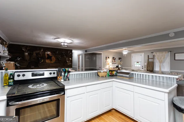 a kitchen with a stove and white cabinets