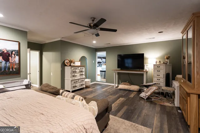 a bedroom with a bed a flat screen tv and a couch