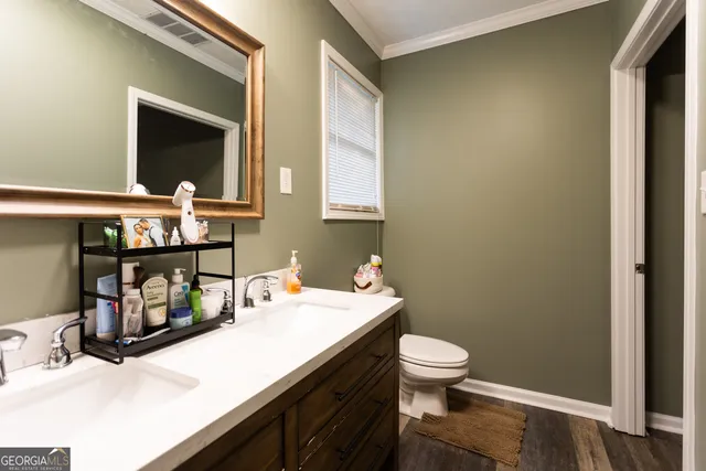 a bathroom with a sink a toilet and mirror