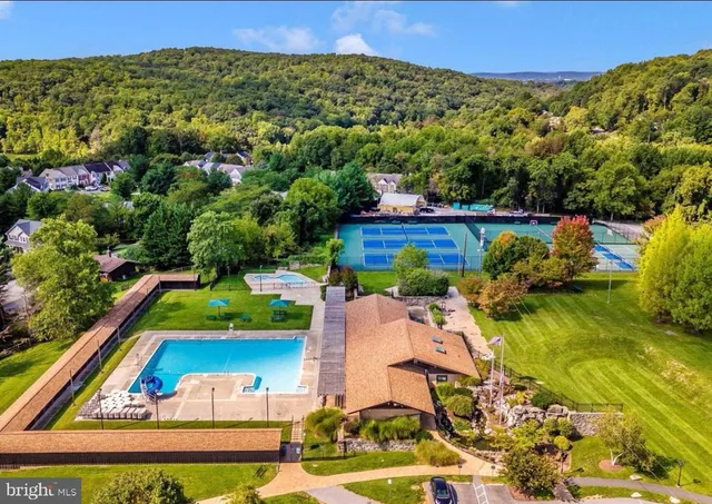 an aerial view of residential houses with outdoor space and swimming pool