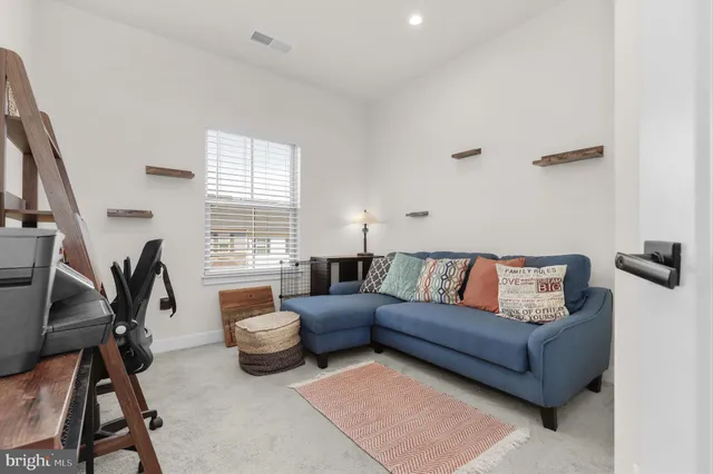 a living room with furniture a air conditioner and a window