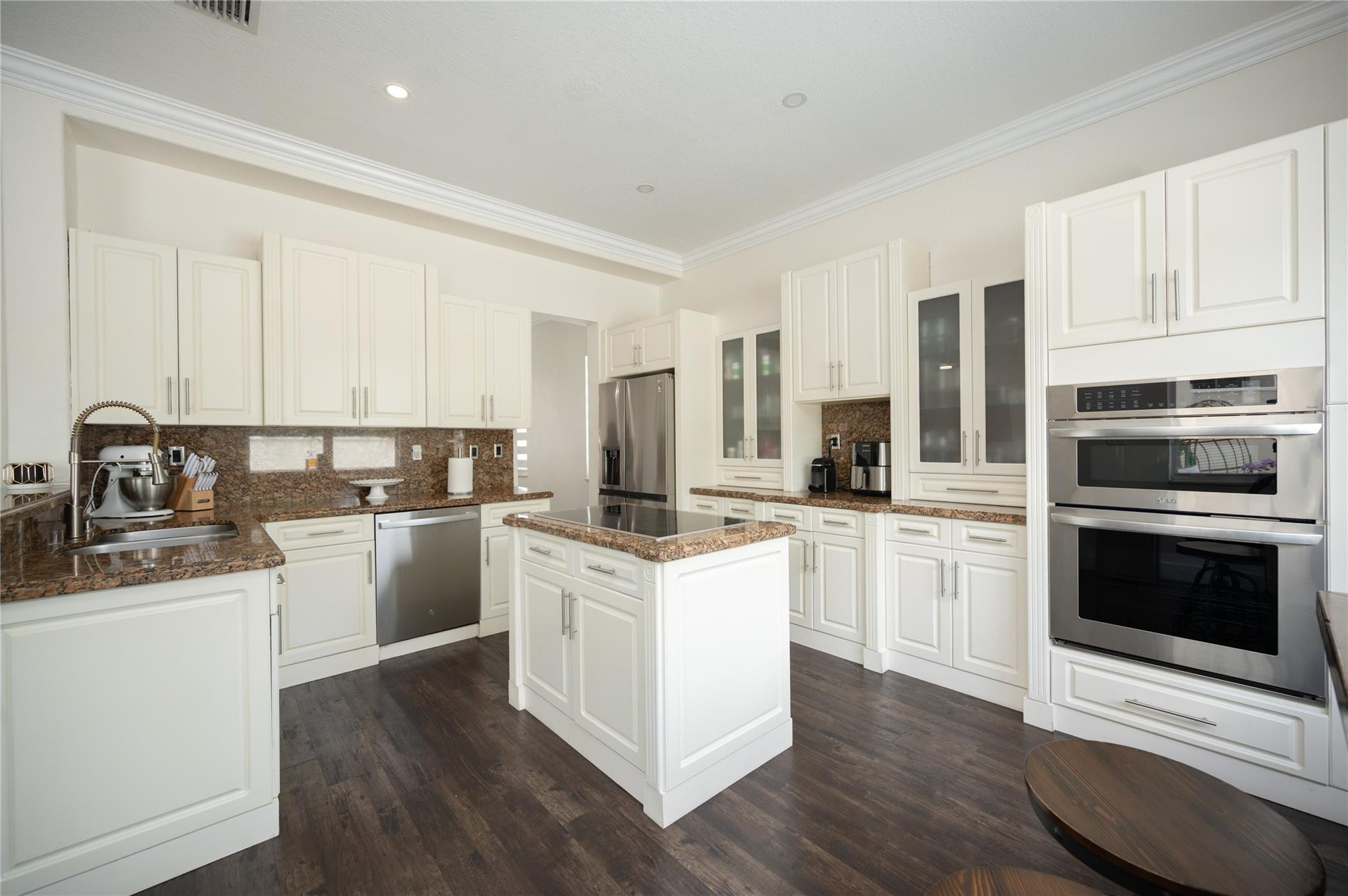 8891 Northwest 178th Lane Hialeah, FL 33018 - Photo 8 of 42 a kitchen with stainless steel appliances granite countertop a stove top oven a sink a refrigerator and white cabinets with wooden floor