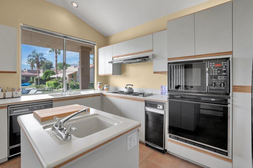 9 Lakeshore Drive Rancho Mirage, CA 92270 - Photo 23 of 41 a kitchen with a stove a sink and a microwave