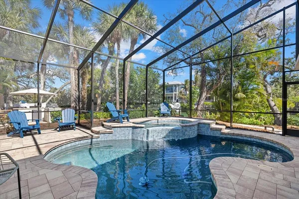 a kitchen with stainless steel appliances kitchen island granite countertop a table chairs and a wooden floor
