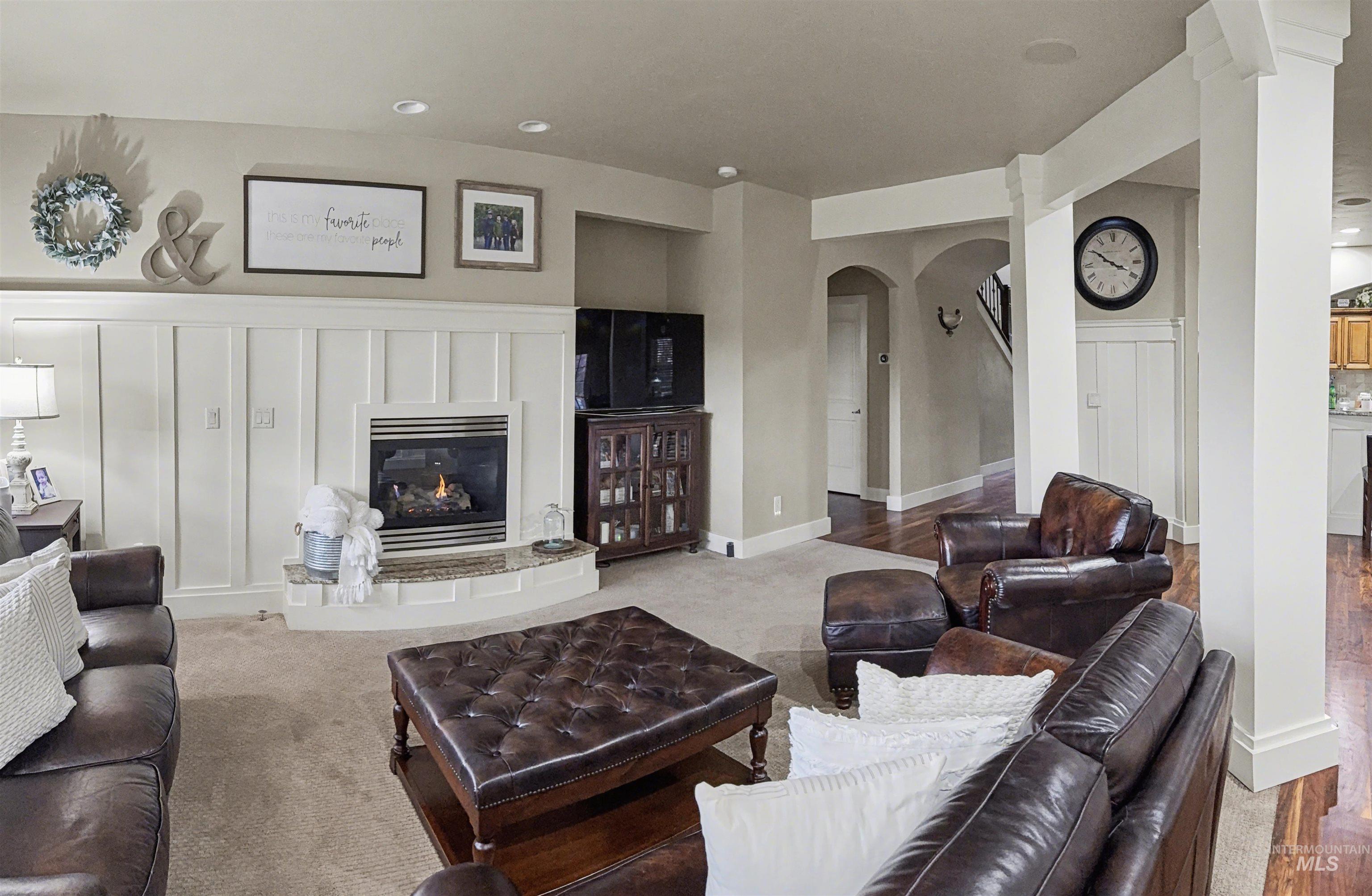 2425 South Chipper Way Eagle, ID 83616 - Photo 25 of 43 Living room featuring a glass covered fireplace, arched walkways, and recessed lighting