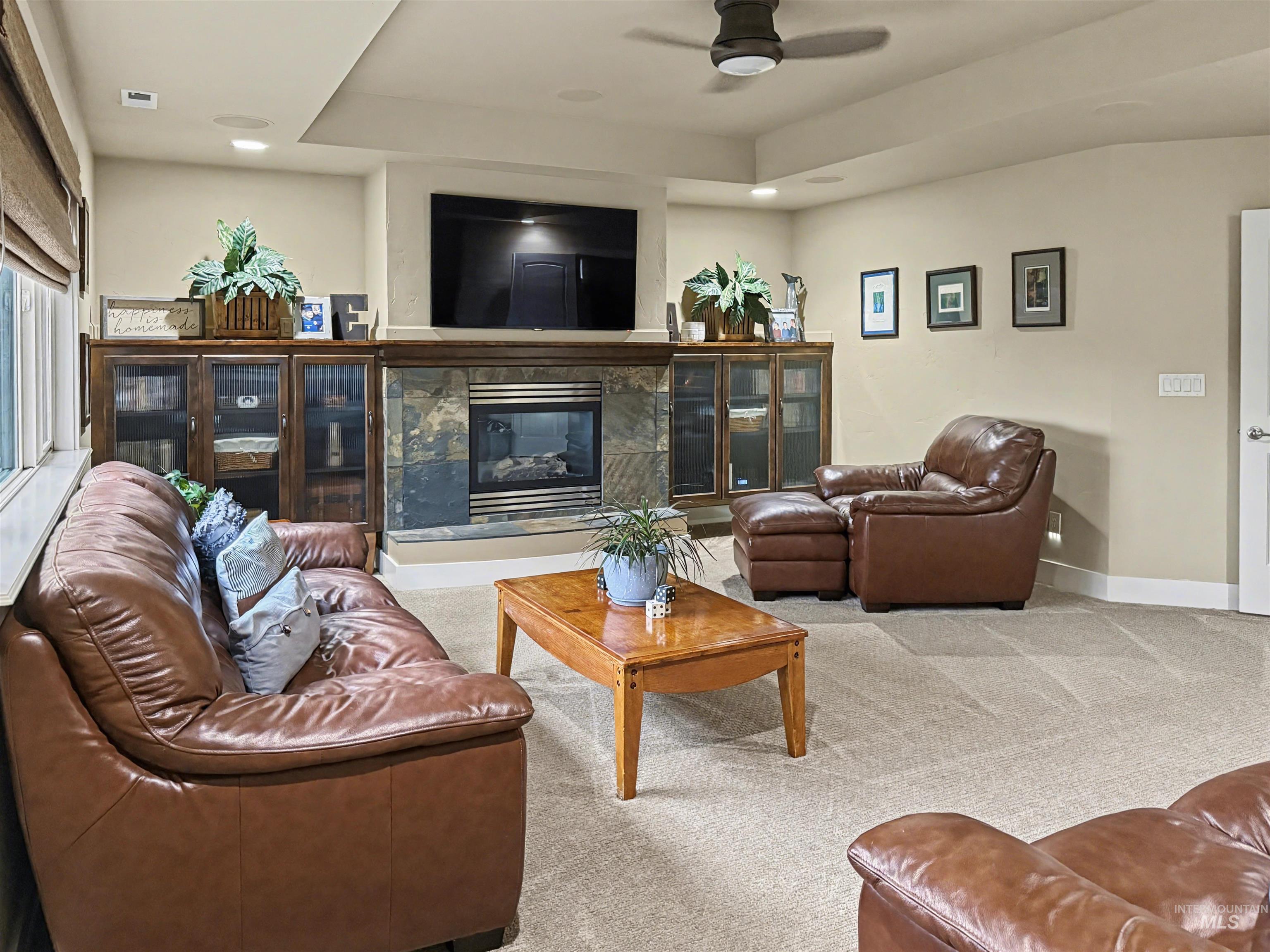 2425 South Chipper Way Eagle, ID 83616 - Photo 27 of 43 Carpeted living area featuring a fireplace, recessed lighting, a ceiling fan, and a raised ceiling