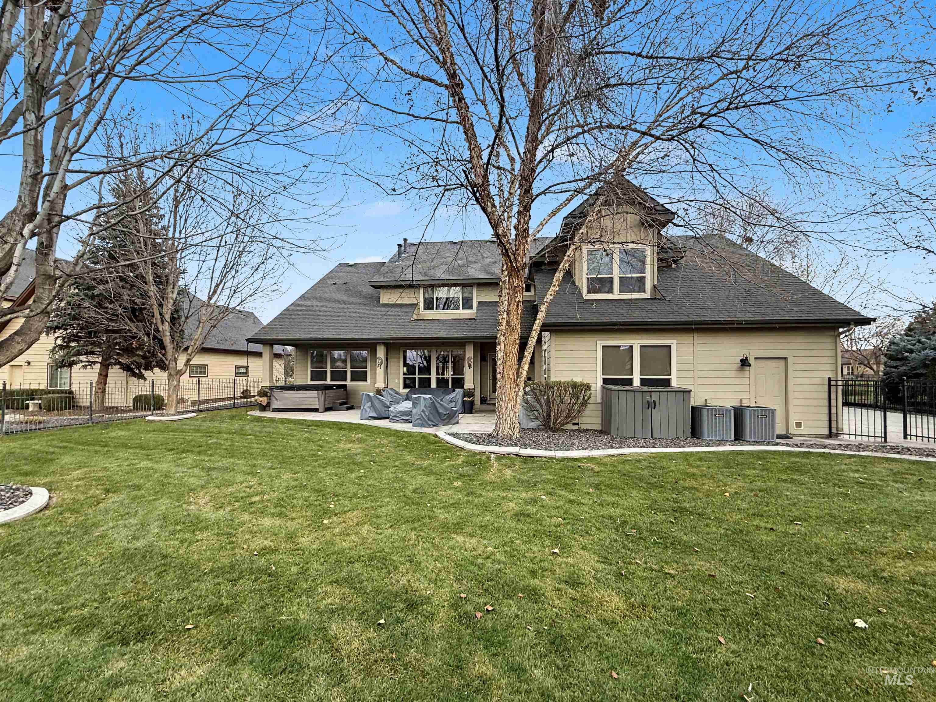 2425 South Chipper Way Eagle, ID 83616 - Photo 4 of 43 Rear view of house with a hot tub, a fenced backyard, a patio, and a shingled roof