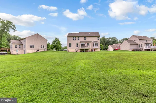 a view of a house with a big yard and large trees