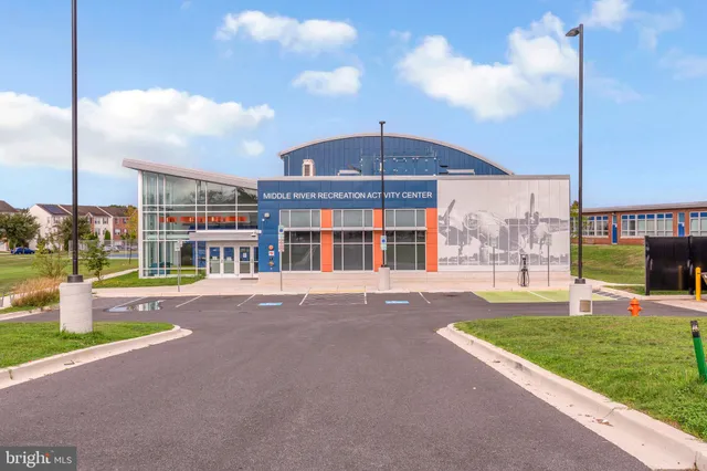 a view of an empty room with wooden floor and a lake view