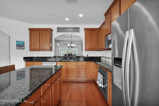 a kitchen with stainless steel appliances granite countertop sink refrigerator and microwave
