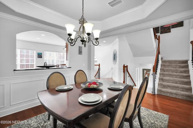 a dining room with furniture a chandelier and wooden floor