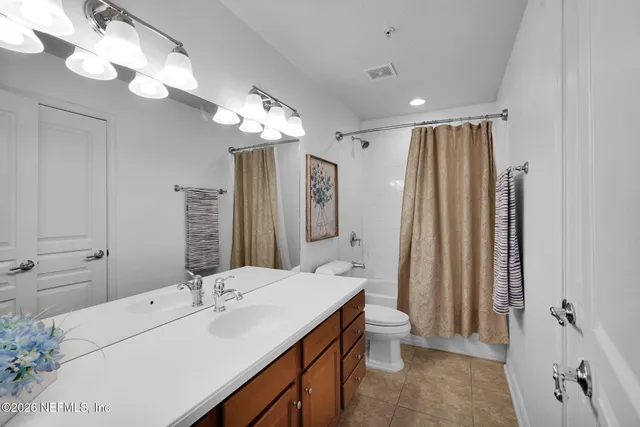 a bathroom with a double vanity sink mirror and toilet