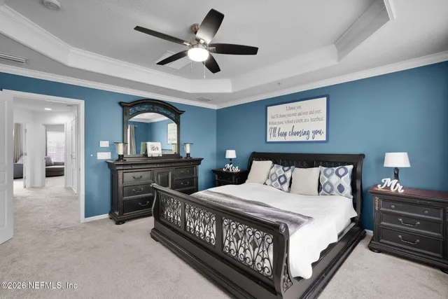 a bedroom with a bed a dresser and potted plants